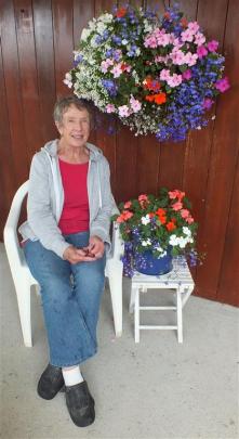 Veronica Fisher sits under one of the hanging baskets she planted.Photos by Gillian Vine.