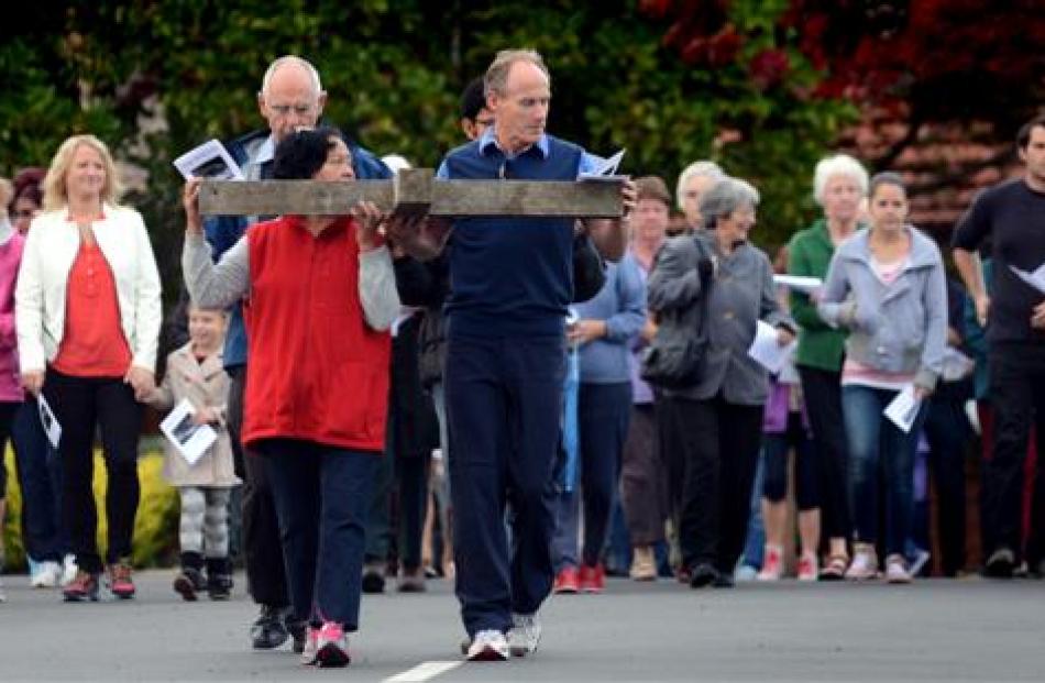 Vise MacKinlay (left) and Gerald Scanlan carry the cross from St Mary's Catholic Parish in...