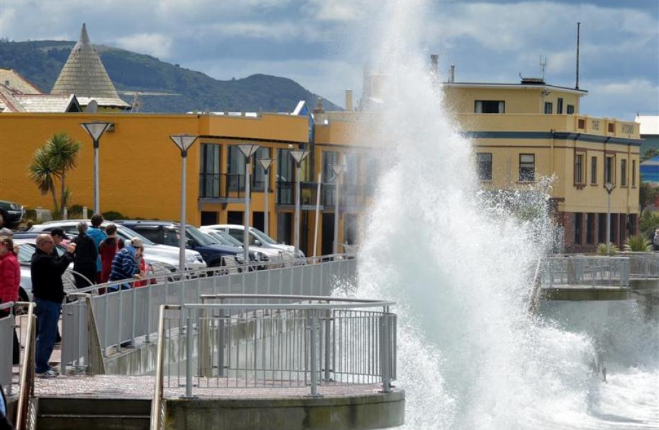 Visitors photograph waves pounding the Esplanade sea wall at St Clair yesterday. Photo by Stephen...