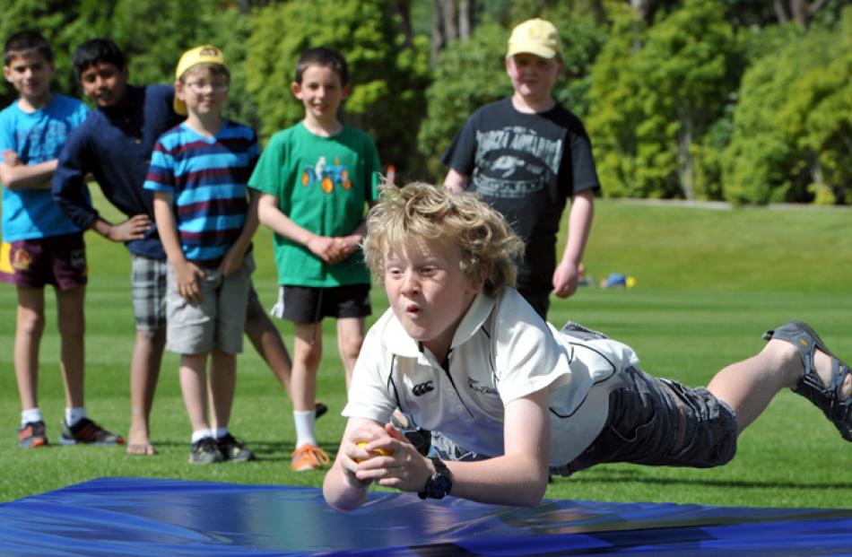 Xavier Chisholm (9), of Dunedin, waits for the impact as he dives to catch a cricket ball.