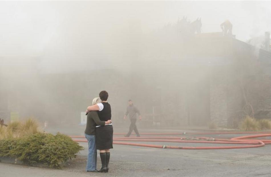 Waihola Tavern co-owner Annette Reid is comforted by daughter Paula Dore as fire extensively...