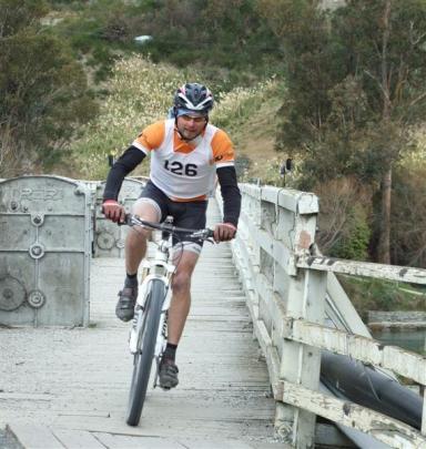 Warren Bates, part of the winning ProActive Physio 1 team, cycles over the Kawarau Falls bridge....