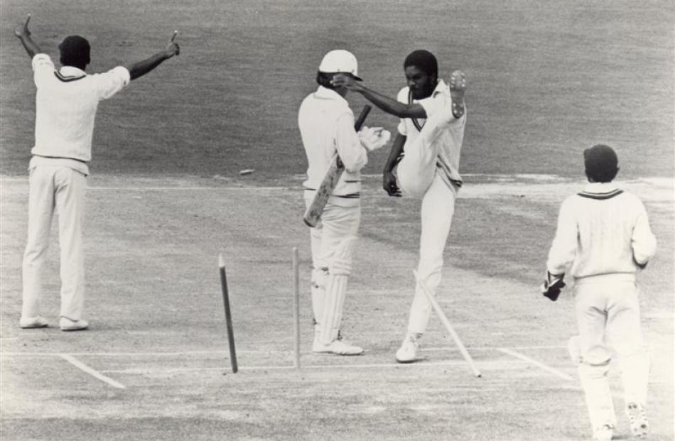 West Indian fast bowler Michael Holding kicks over the stumps in frustration after a decision for...