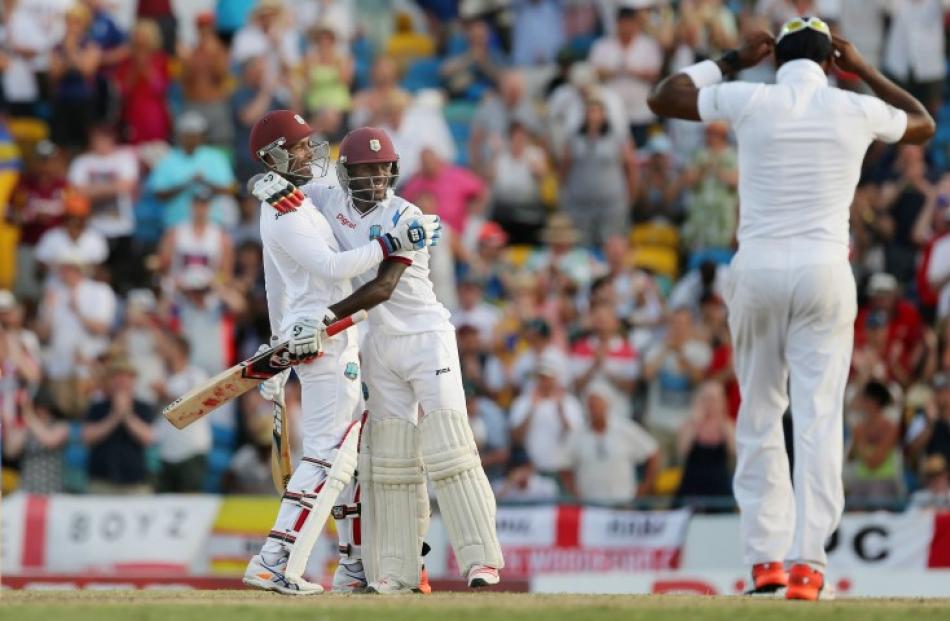 West Indies batsmen Denesh Ramdin and Jermaine Blackwood celebrate their victory over England....