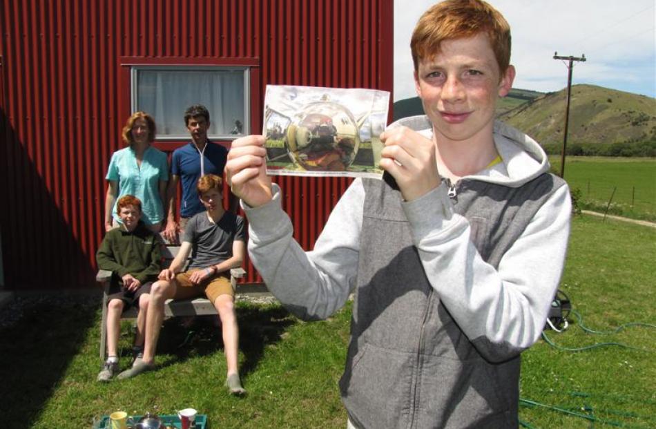 William Lorimer (14) displays his winning photo while mum Michelle, dad Mike and brothers Tom (10...