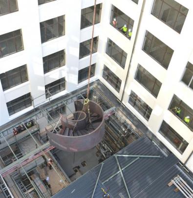 Workers prepare to lift the staircase into the former chief post office building in Bond St, in...