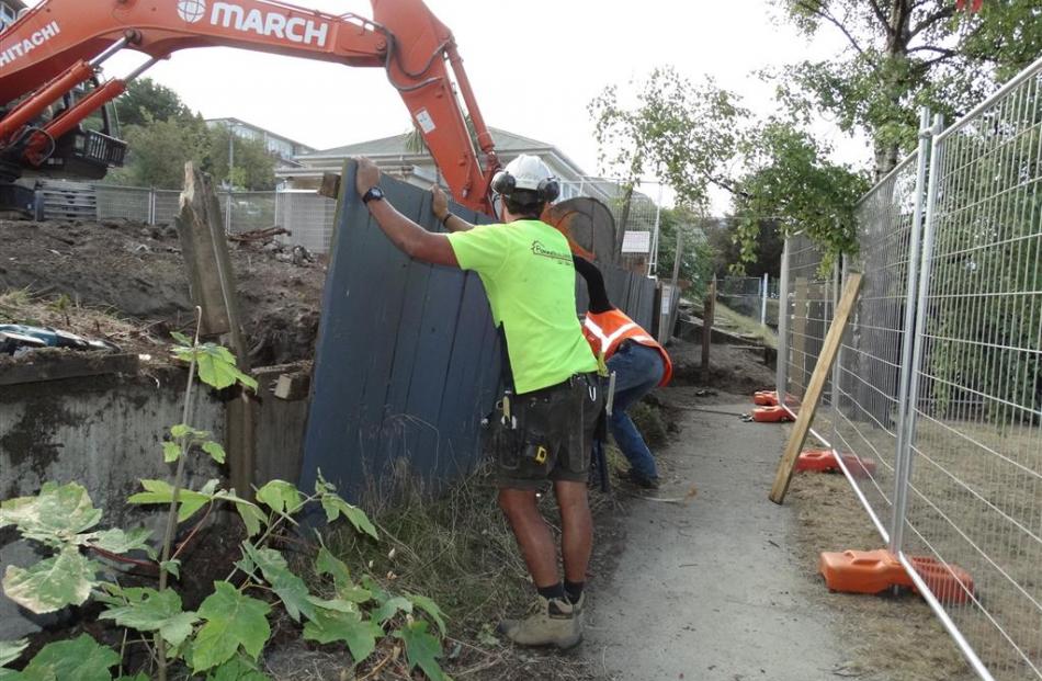 Workmen take down a fence which separates Queenstown Playcentre from an active building site in...