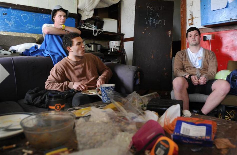 WORST FLAT: Sam Coombs (21), Josh Packer (20) and Jamie Lockyer (19) sit among the filth in the...