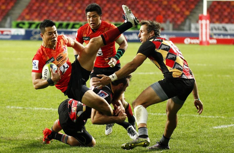 Akihito Yamada of the Sun Wolves (left) is tackled by Jaco van Tonder of the Southern Kings...