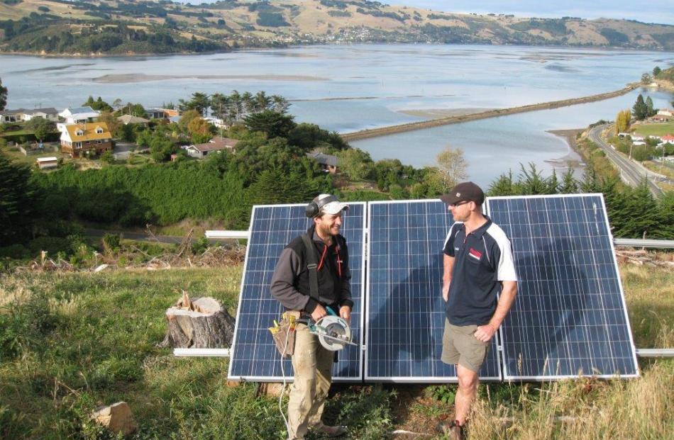 Builder Richy Kvick (left)  and electrician  James Hardisty  with the solar panels at Blanket Bay...