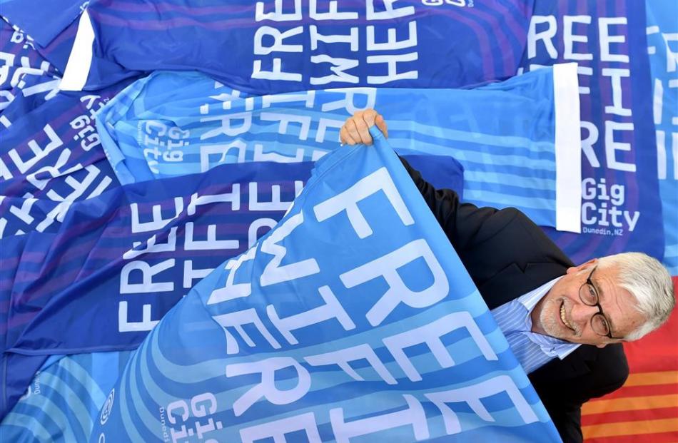 Digital Community Trust chairman John Gallaher surrounded by GigCity flags last year. Photo by...