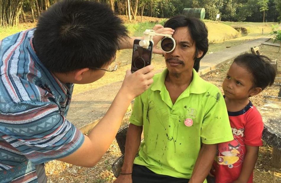 Dr Hong Sheng Chiong checks a patient for eye illness in Borneo. Photo supplied.