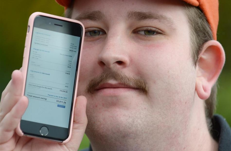 Eden Burns, of Mosgiel, with his phone which he took on holiday and returned with a $10,000...