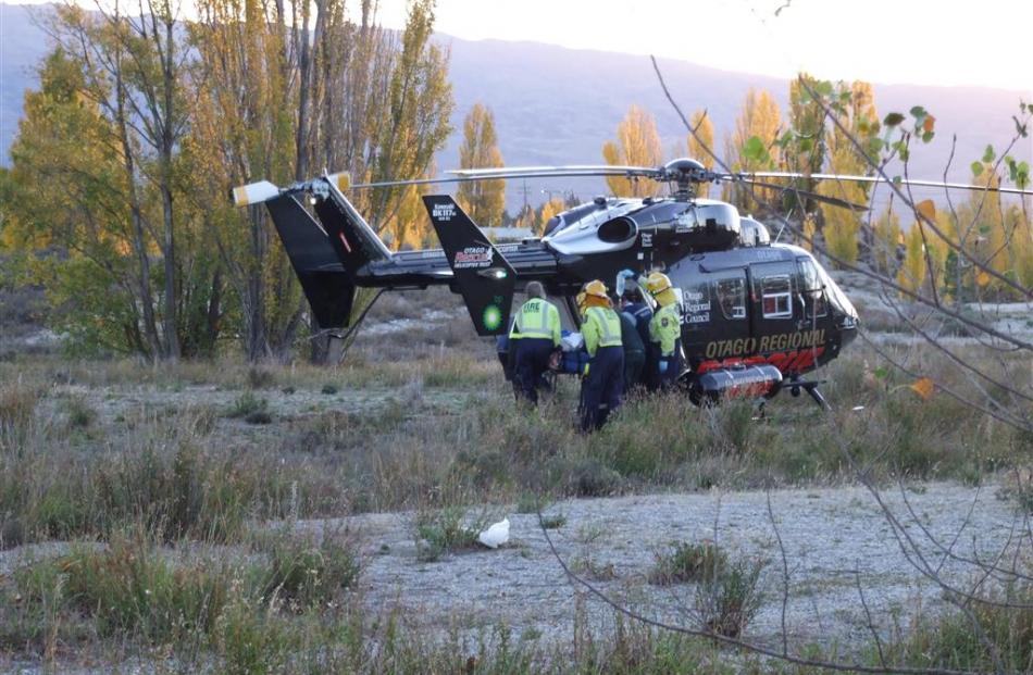 Emergency services staff carry a man to the Otago Regional Rescue Helicopter. Photos by Lynda van...
