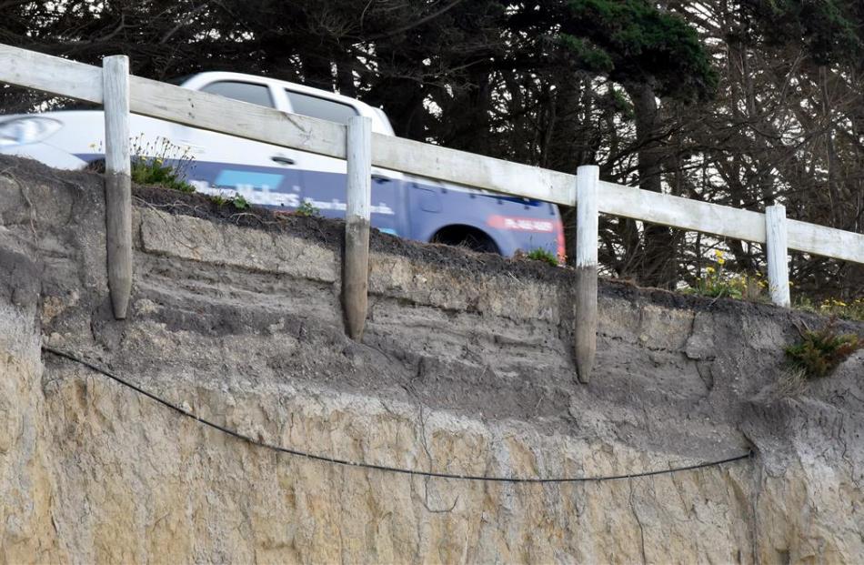 Erosion along Taieri Mouth Rd has exposed three fence posts, a telecommunications cable and the...