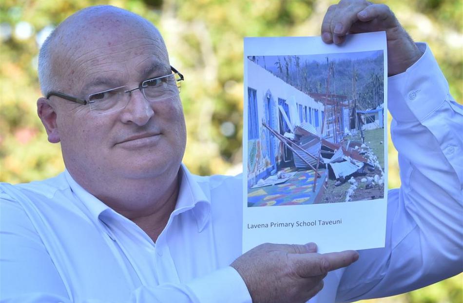 Mosgiel Rotarian Lindsay Thorburn with a photograph of a school in Fiji destroyed by Cyclone...