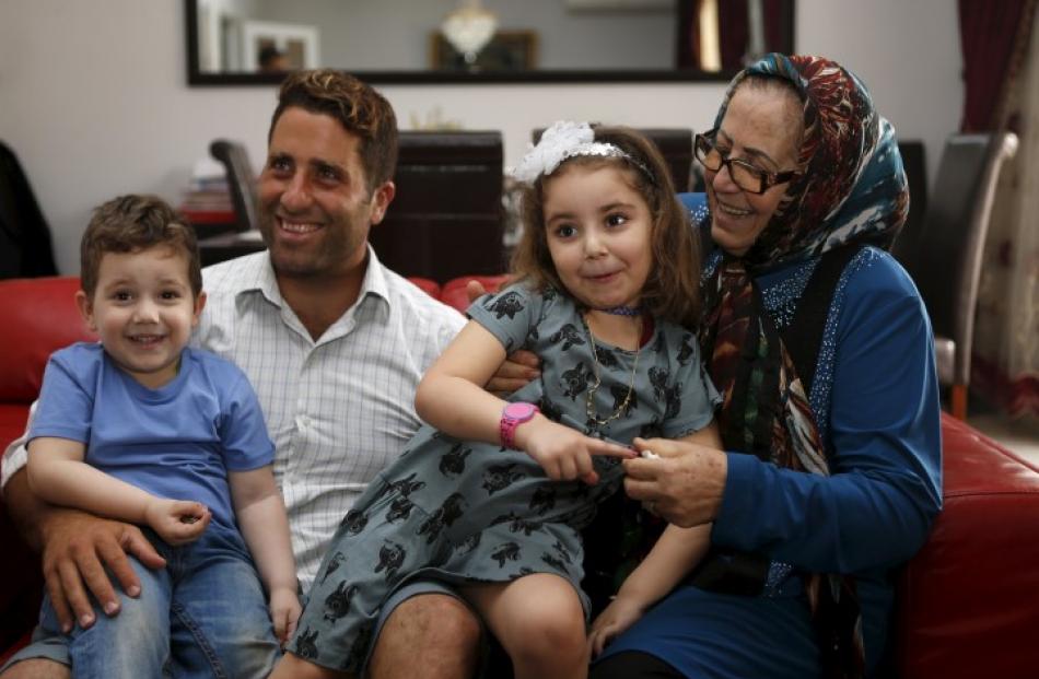 Noah (L) and Lahela al-Amin with their father Ali Zeid al-Amin and grandmother in their family...