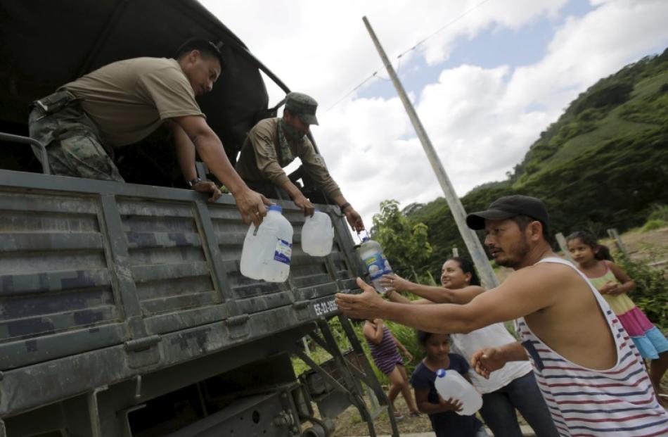 Soldiers give donations of bottled water to residents in Ecuador. Photo: Reuters