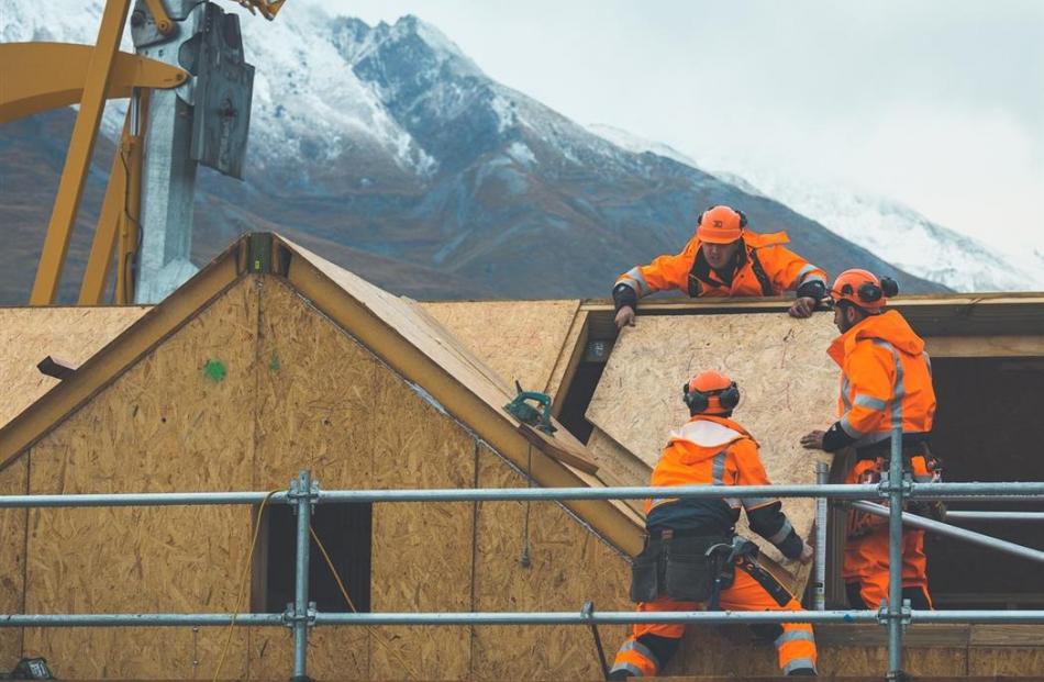 Contractors work to fit roof panels to the first sustainable cabin at Camp Glenorchy. Photo by...