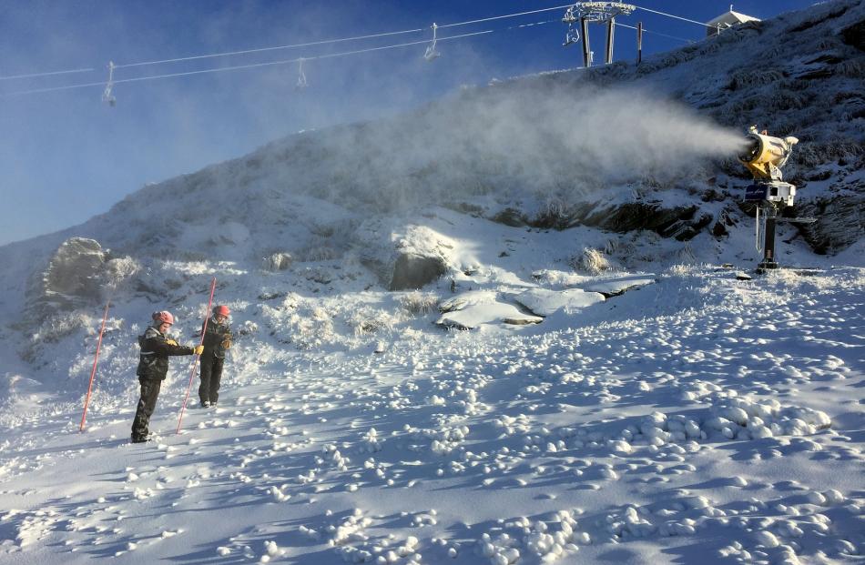 Coronet Peak snow-making team members Jake Reilly (left) and Lucy Ruck measure the snow on the...