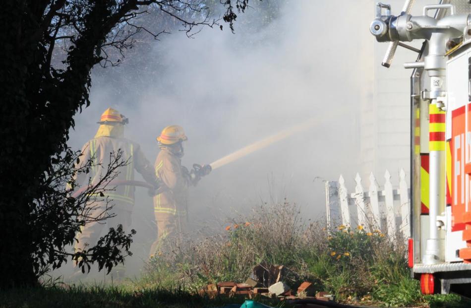 Fire crews work to put out a blaze in an unoccupied house in Lune St, Oamaru, yesterday. Photos...