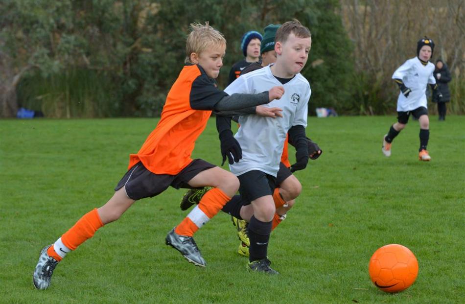 Luke Marsh (9, right), of Roslyn-Wakari Broncos, attempts to shoot at goal while  challenged by...