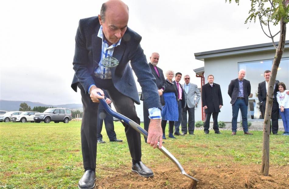 Ngai Tahu kaumatua Edward Ellison places soil around a kowhai tree, as part of the official...