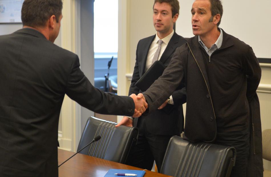 Scott Willis (right) shakes hands with Dunedin City Council processing planner Darryl Sycamore,...