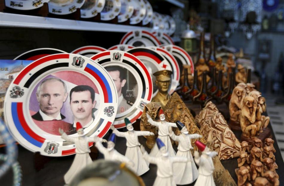 Souvenir plates depicting Syria's President Bashar al-Assad and Russia's President Vladimir Putin...