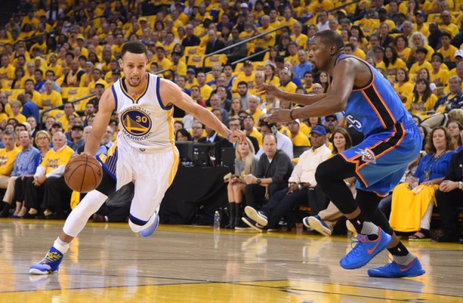 Stephen Curry drives to the hoop as Kevin Durant comes across to guard him. Photo: Reuters