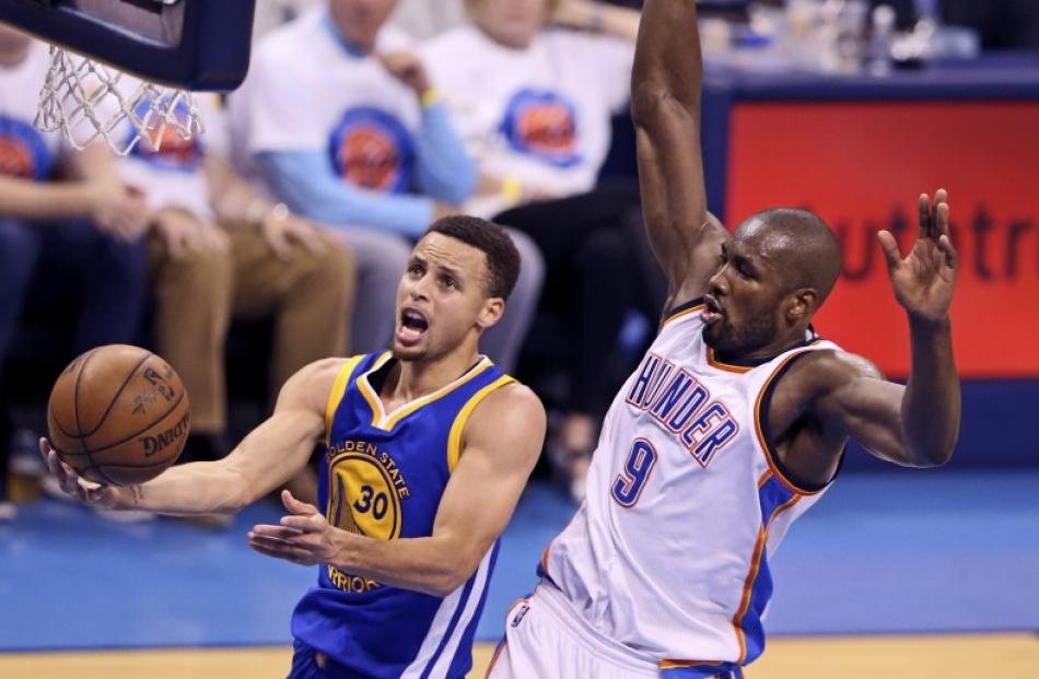 Stephen Curry takes the ball to the hoop as Serge Ibaka tries to stop him. Photo: Reuters