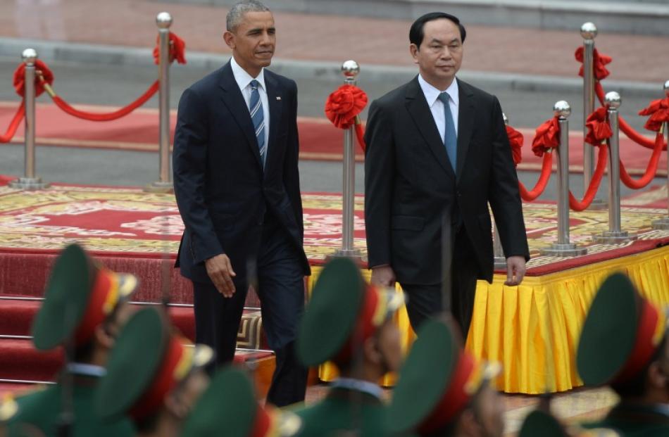 US President Barack Obama and his Vietnamese counterpart Tran Dai Quang review an honour guard...