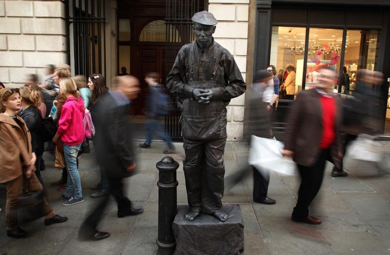 Visitors enjoy street acts and shopping in Covent Garden. Photo: Getty Images
