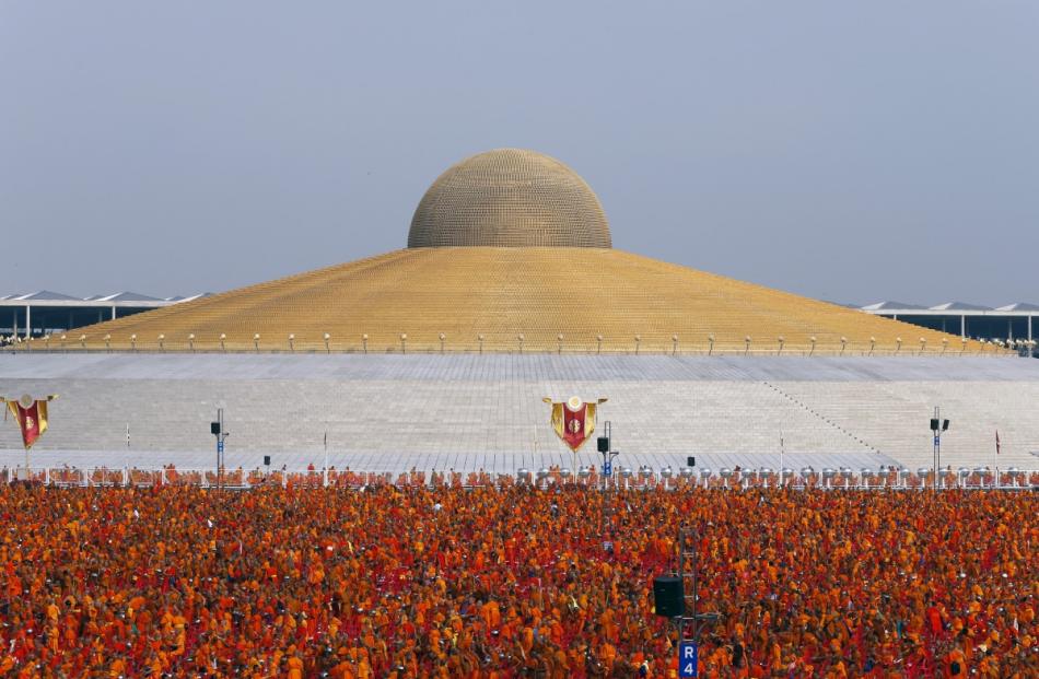 Buddhist monks and novices gather to receive alms at Wat Phra Dhammakaya temple in Pathum Thani,...