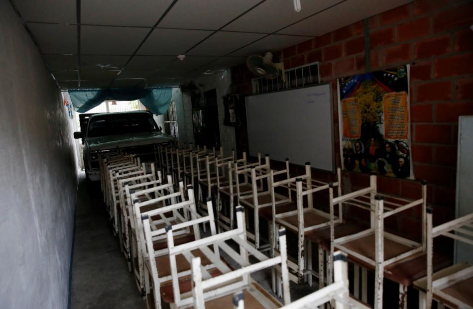 Desks are seen at an improvised classroom in a garage of a house, which is part of state school...