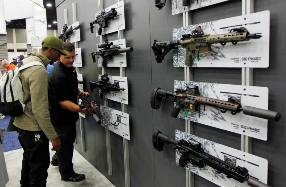 NRA gun enthusiasts view Sig Sauer rifles at the National Rifle Association's annual meetings &...
