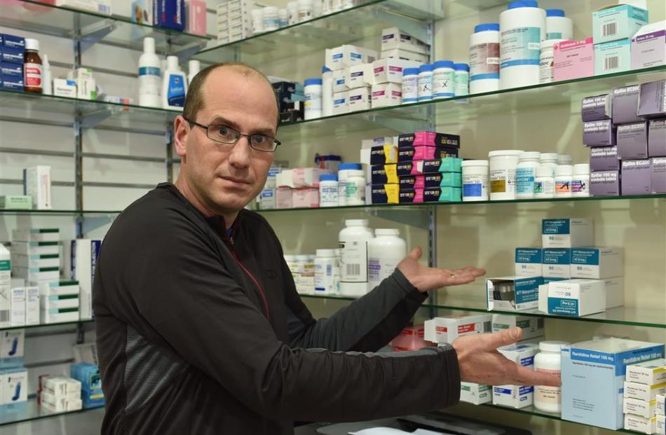 Waihemo Pharmacy owner Adrian Graamans points to shelves that should be fully stocked with...