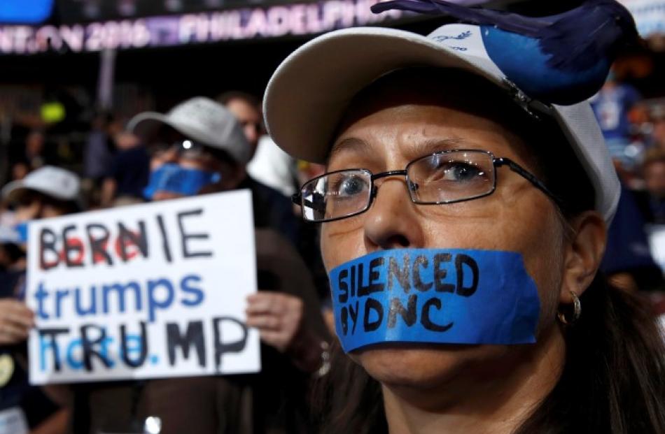 A Bernie Sanders supporter wears tape across her mouth in protest at the Democratic National...