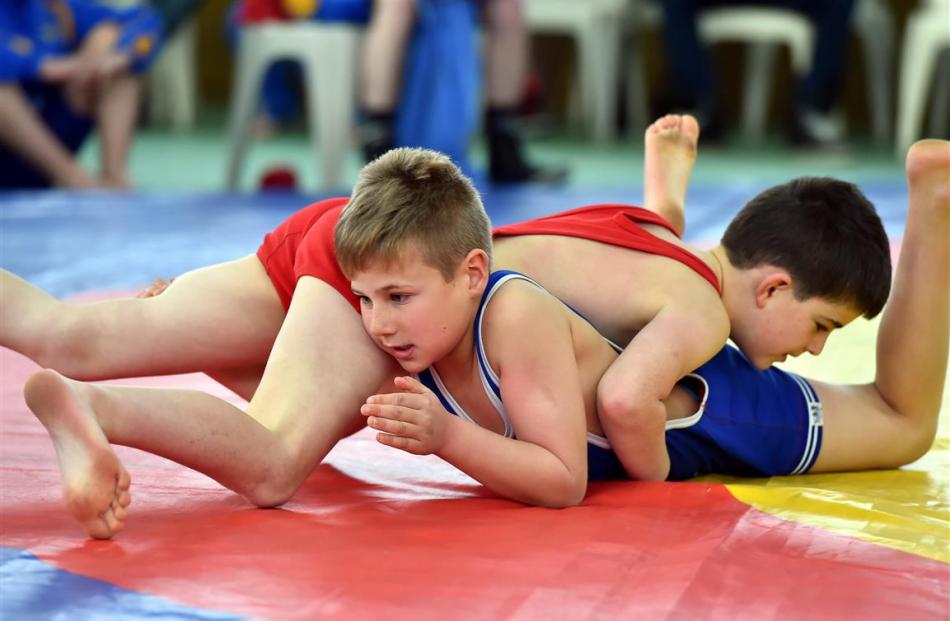 Fletcher Baxter (in red), and Isaac Sinclair, (in blue), both of the Taieri Wrestling Club, take...