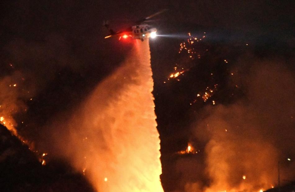Helicopters drop water on the wildfires. Photo: Reuters