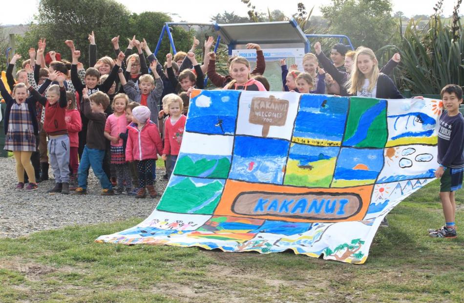 Holding a banner made for the occasion are (from left) Lily Perkins (11), Maya Murray (11) and...