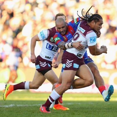 Martin Taupau carries the ball for Manly as he is tackled by Jeremy Smith of Newcastle. Photo:...