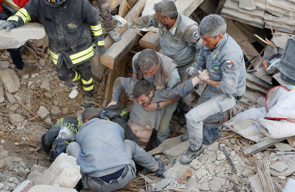 A man is rescued alive from the ruins following an earthquake in Amatrice, central Italy. Photo:...