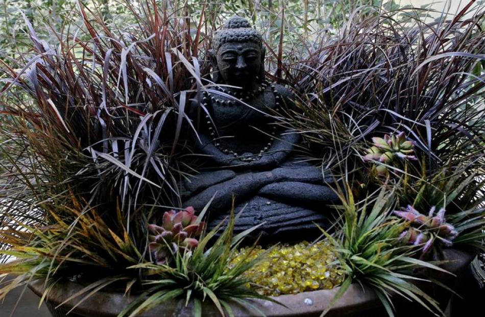 A Buddha that Adam Isaacs bought in Bali sits in a large oval pot surrounded by fake fountain...