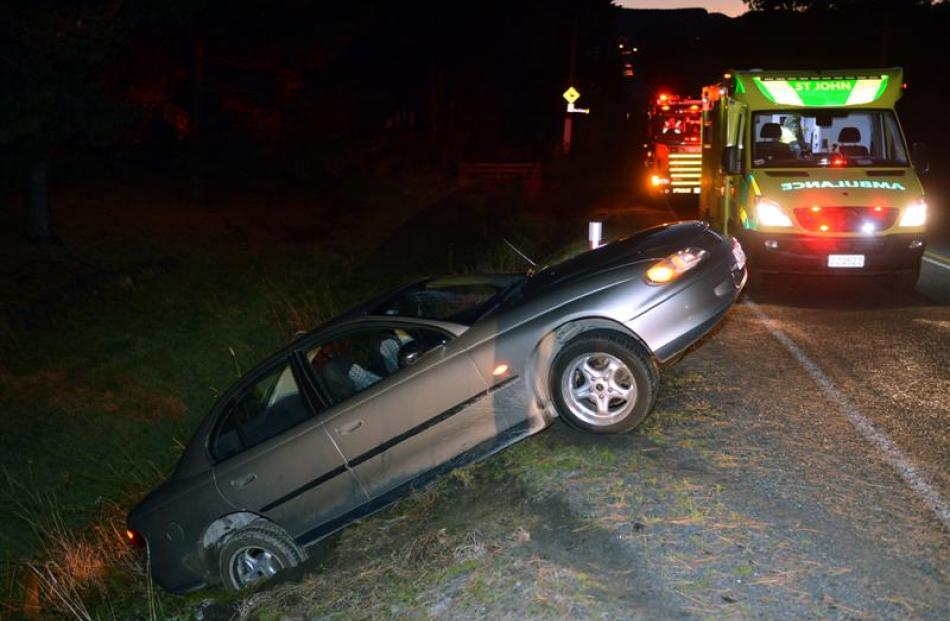 A car sits partly in a ditch after leaving Brighton Rd yesterday. Photo by Stephen Jaquiery.