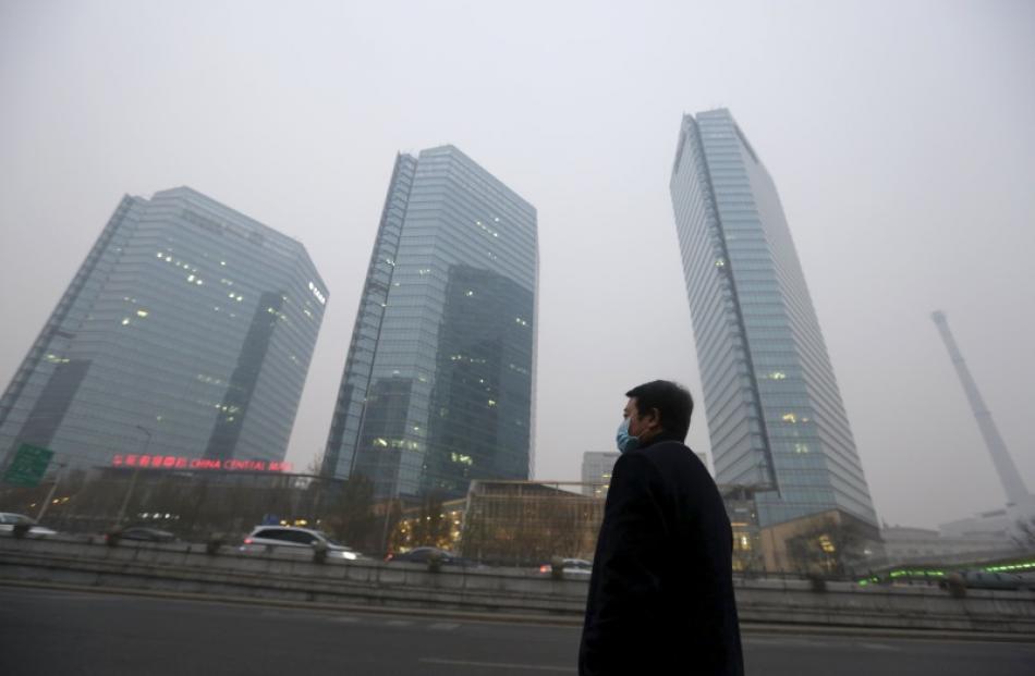 A man waits for a taxi amid heavy smog in Beijing. Photo: Reuters