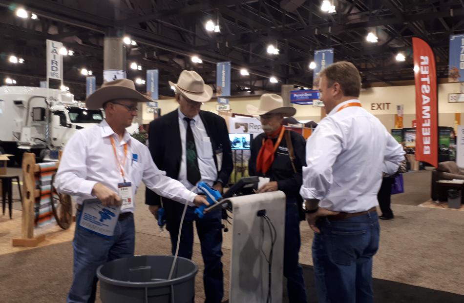 Te Pari Products' United States representative Brian Siekman (left), brand ambassador Baxter Black (third from left) and sales and marketing director Jeremy Blampied (right) discuss drenching options with a customer at the National Cattlemen's Beef Associ