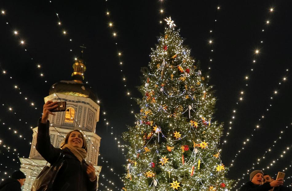 In the Ukraine, people take selfies in front of the St. Sophia Cathedral in central Kiev. Photo:...