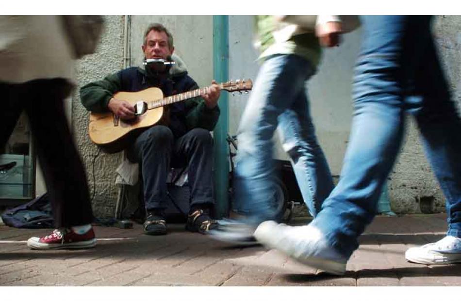 Hustle and Bustle...Dunedin singer - songwriter Phil Corfield busks in Albion Place yesterday...