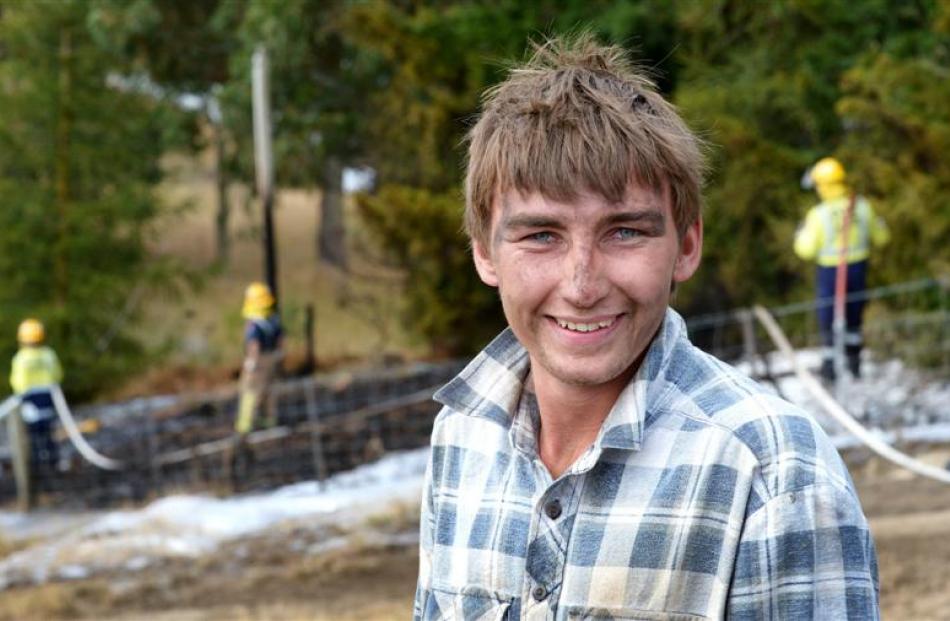 Jake Bridson relaxes after helping battle a grass fire near Clarks Junction yesterday. Photos by...